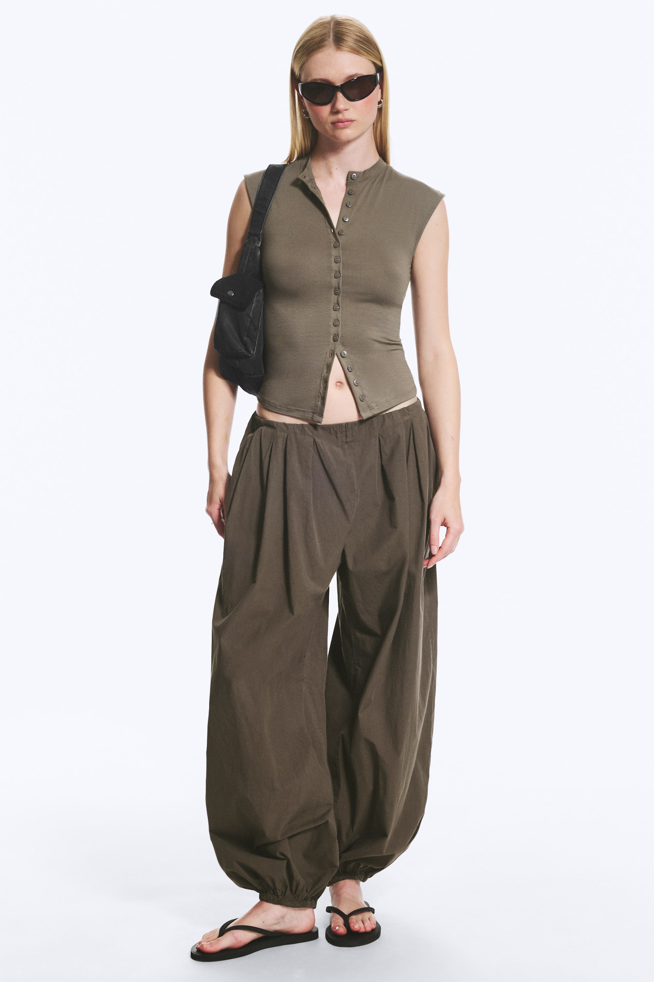 Visualizza immagine più grande: Un pantalone a palloncino realizzato in morbido cotone è indossato dalla modella. La vita elastica con pieghe e il bordo inferiore elasticizzato creano una vestibilità facile da infilare con una silhouette definita.