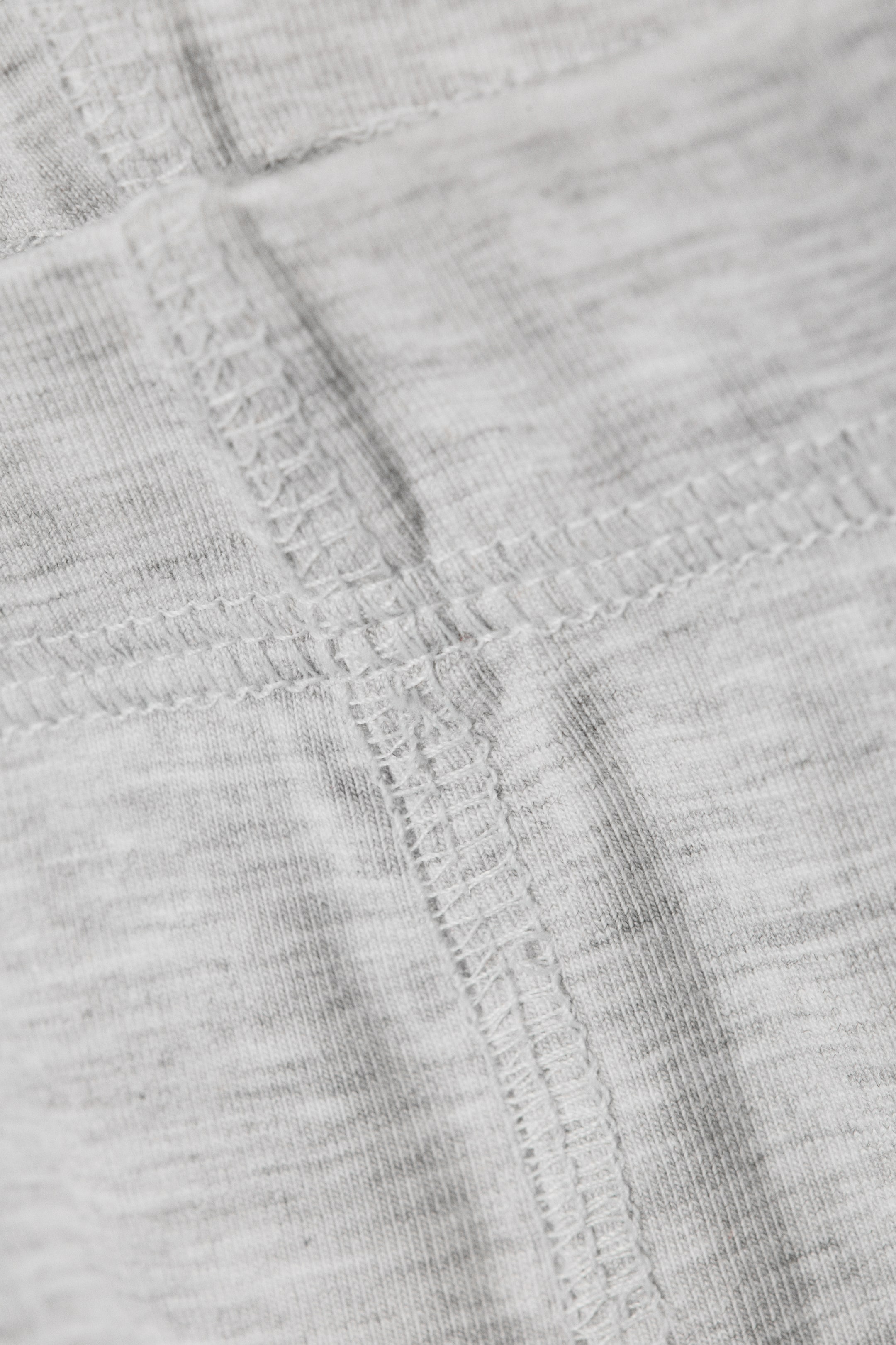Agrandir l'image: Le tissu en maille gris clair chiné présente des détails en gros plan de coutures plates entrecroisées.