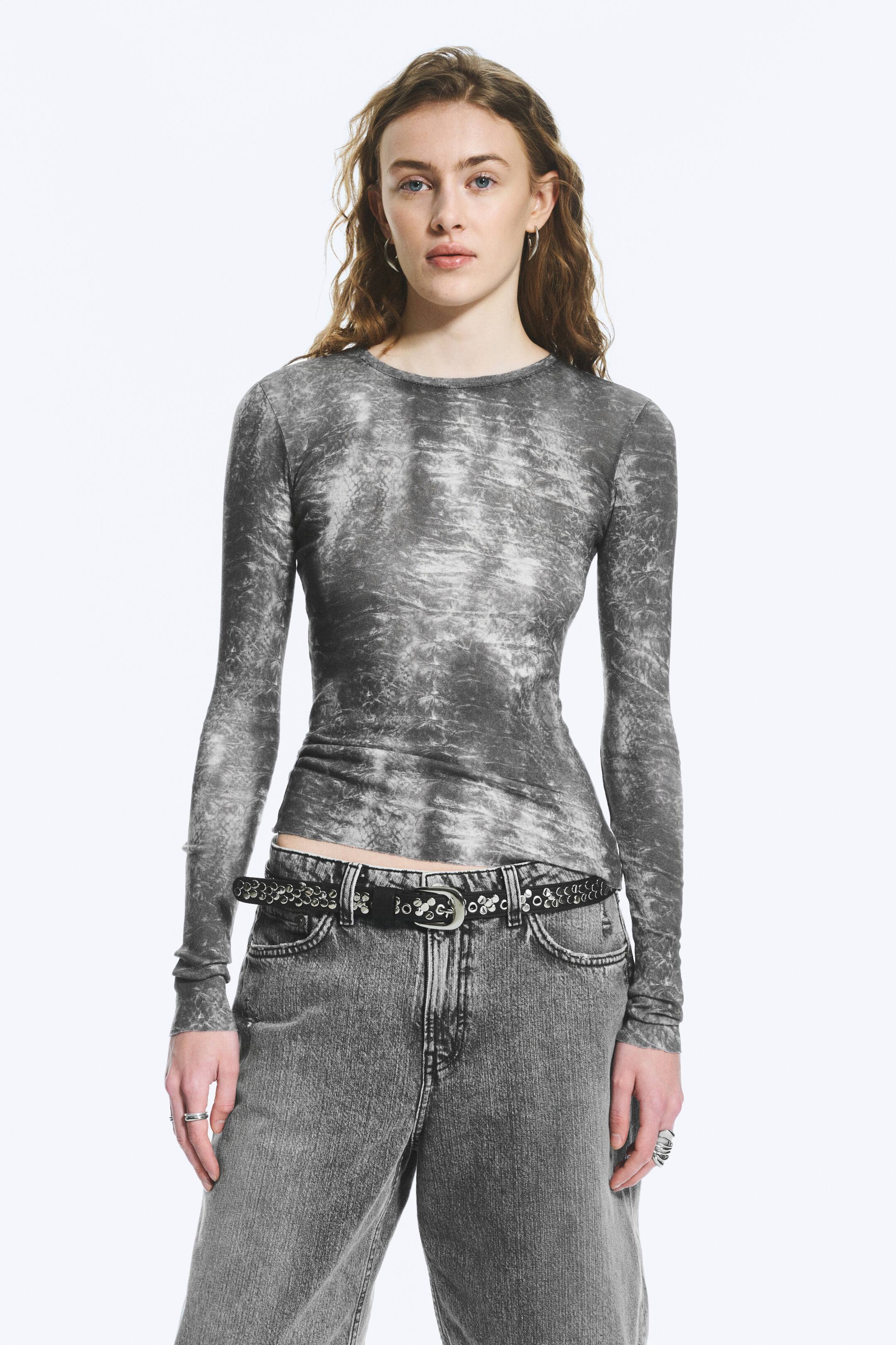 Grotere afbeelding bekijken: Een top met lange mouwen wordt gepresenteerd, met een grijze distressed, gemarmerde print, een ronde hals en een slanke pasvorm.