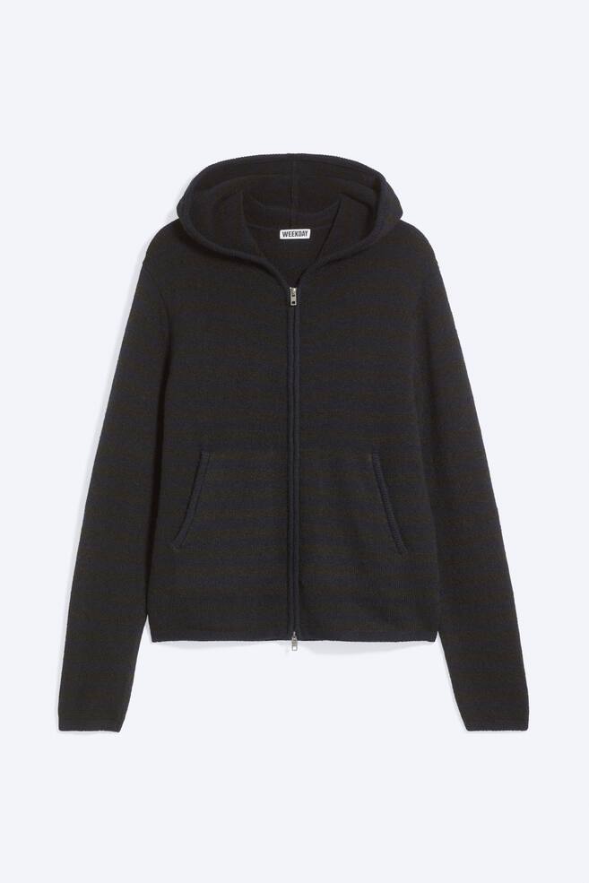 Una felpa con cappuccio e zip in maglia, caratterizzata da righe orizzontali blu navy scuro e nere, Ã¨ mostrata frontalmente, con cappuccio integrato, zip frontale bidirezionale argentata e due tasche frontali oblique. La felpa presenta una vestibilitÃ  morbida con polsini e orlo rifiniti in modo pulito. - 1