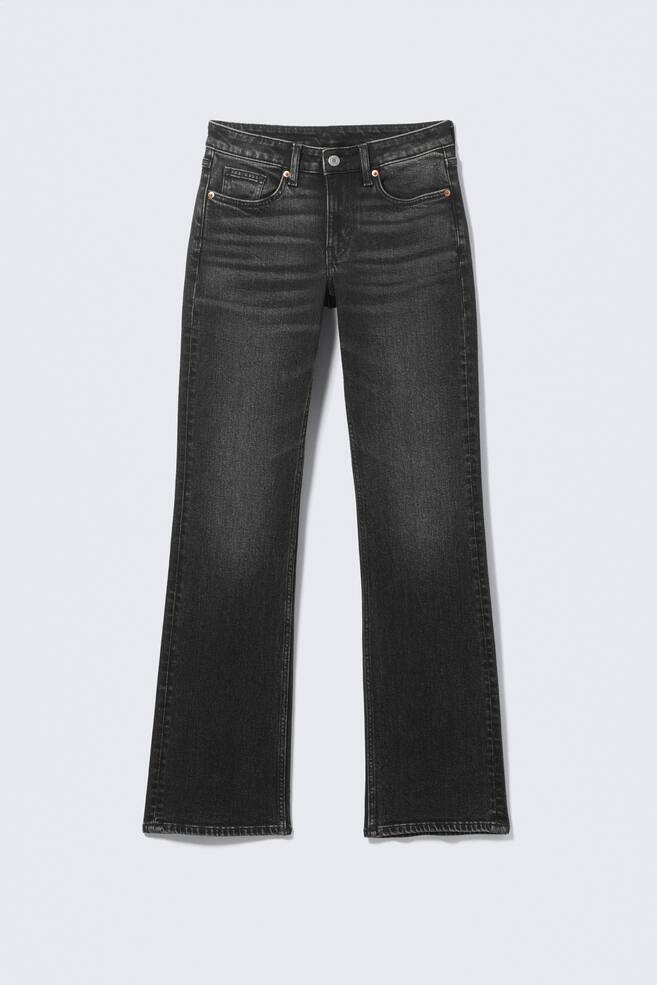 Ein Paar dunkelgraue, schmal geschnittene Jeans wird von FRONT präsentiert. Sie verfügen über eine mittelhohe Taille, Gürtelschlaufen und einen Reißverschluss. Die Jeans zeigen Vordertaschen mit kleinen Metallnieten, eine Münztasche und ein Bootcut-Bein, mit einem verblassten Wascheffekt auf den Oberschenkeln. - 1