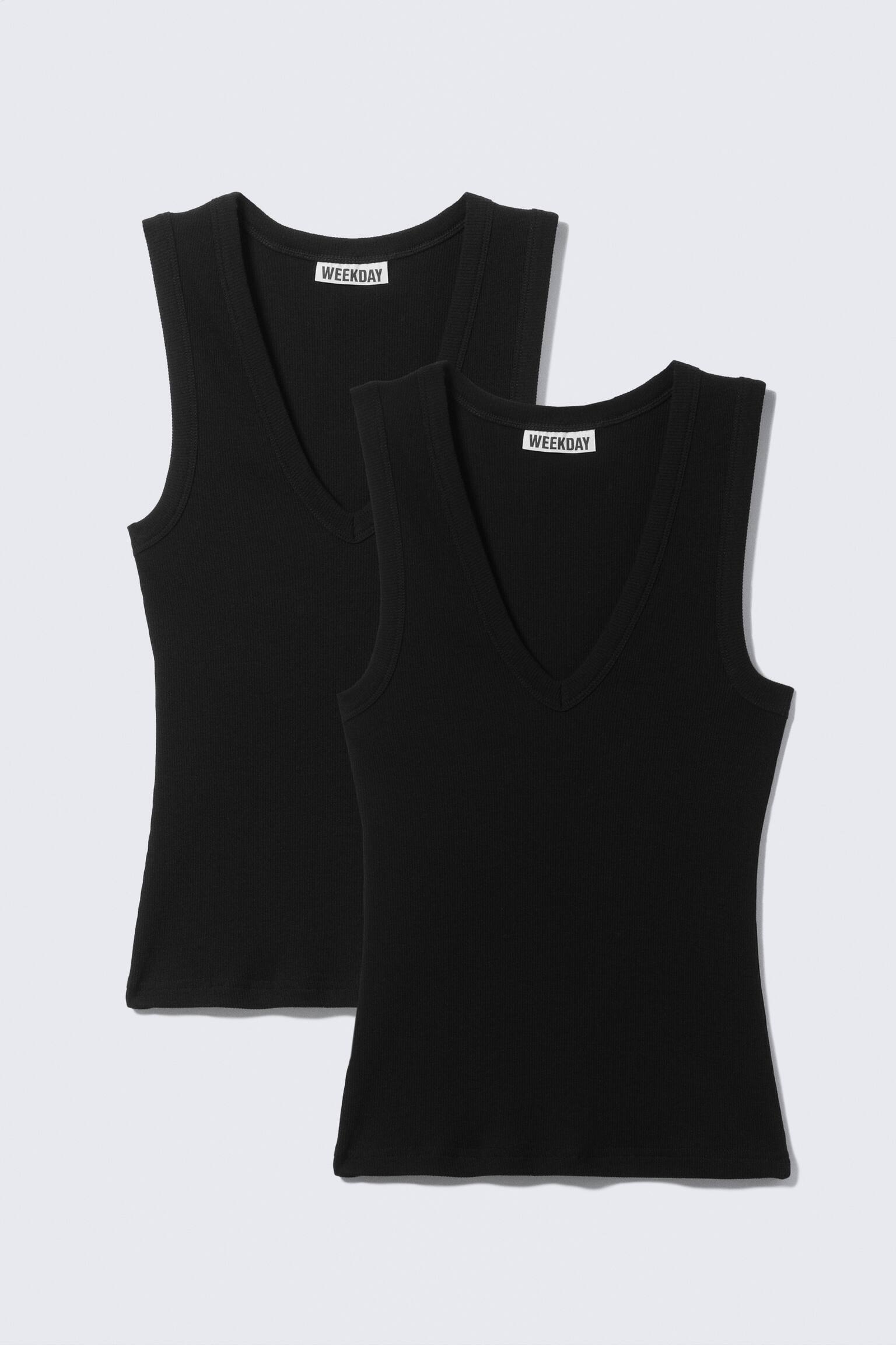Two identical black ribbed tank tops are showcased, each featuring a deep V-neckline and a "WEEKDAY" label at the back collar. Both tank tops are facing forward, with one positioned slightly behind and above the other.