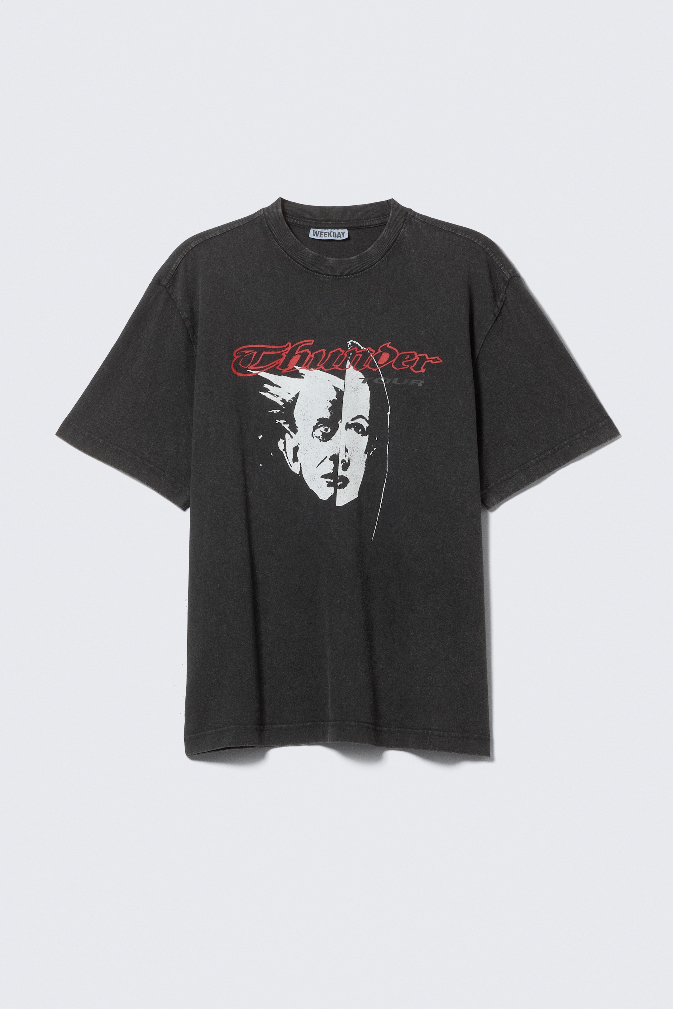 View larger image: A charcoal, relaxed-fit T-shirt is facing FRONT, displaying a graphic print of a white stylized face and red "Thunder Tour" text. It is designed with a ribbed crew neckline, dropped shoulders, and a straight hemline.