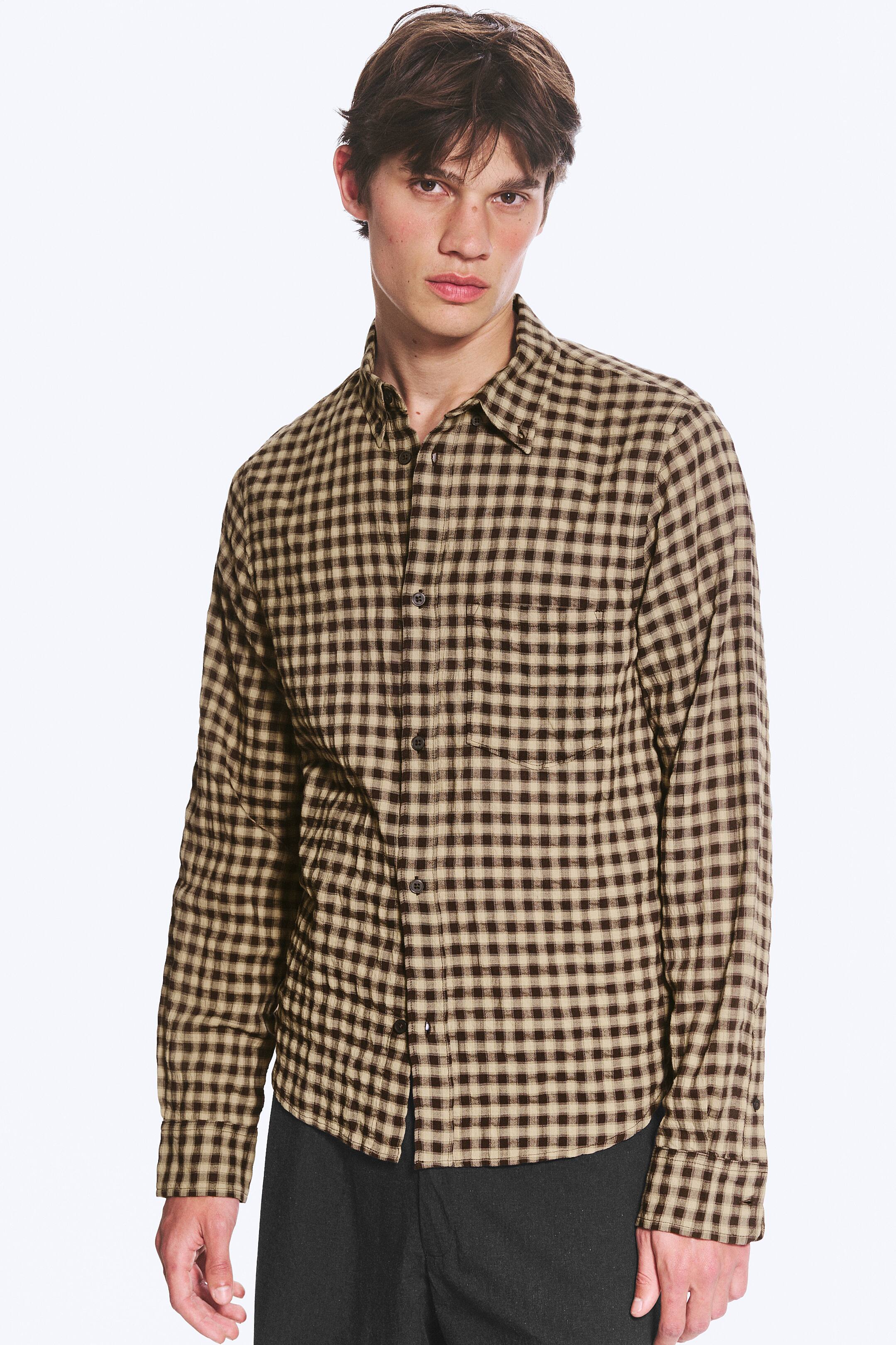 Agrandir l'image: Une chemise à manches longues à carreaux vichy marron et beige est présentée, dotée d'un col boutonné, d'une fermeture à boutons sur le devant, de deux poches poitrine et de poignets boutonnés.