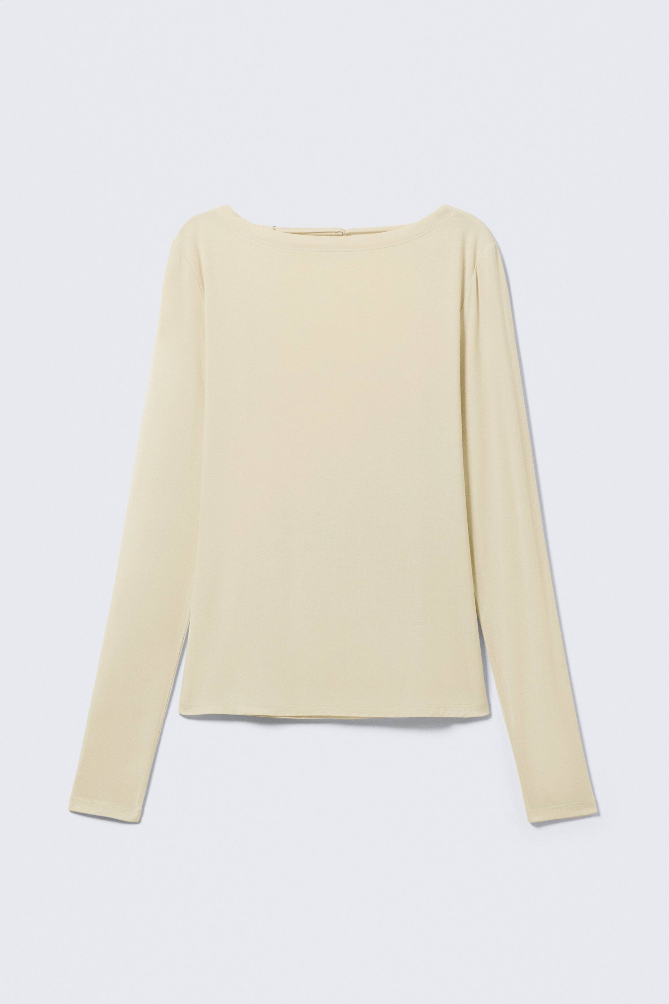 Agrandir l'image: Un haut à manches longues de couleur beige clair est présenté de face, avec un col bateau, des manches longues, et un ourlet droit, mettant en valeur un tissu lisse.