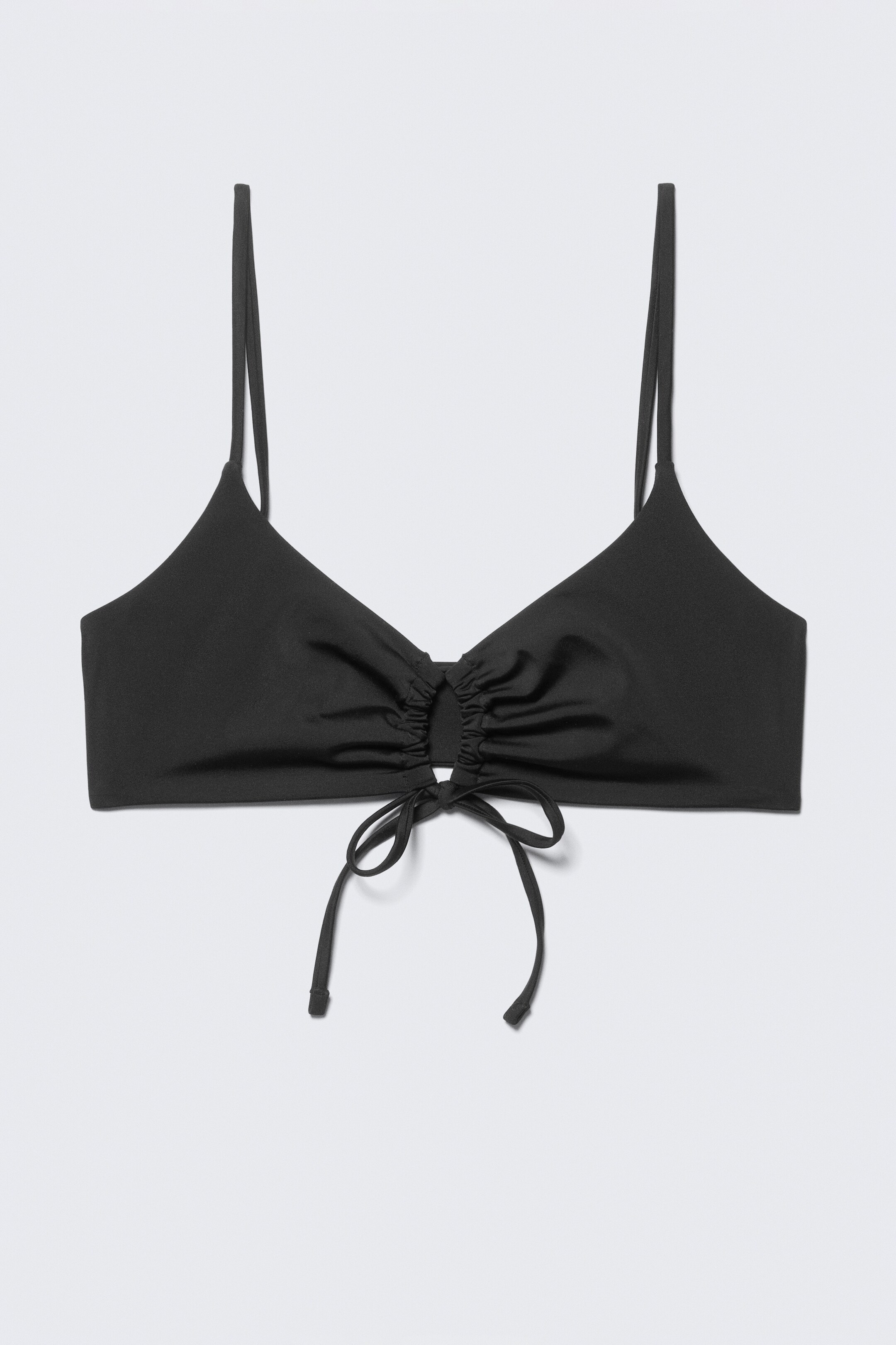 Nagyobb kép megtekintése: Egy fekete minimalista háromszög bikini felső, amelyet az ELŐLAPRÓL mutatnak be, középen redős, ahol keskeny pántok futnak keresztül egy csatornán, és az aljánál kötődnek meg. A tetején állítható vállpántok láthatók.