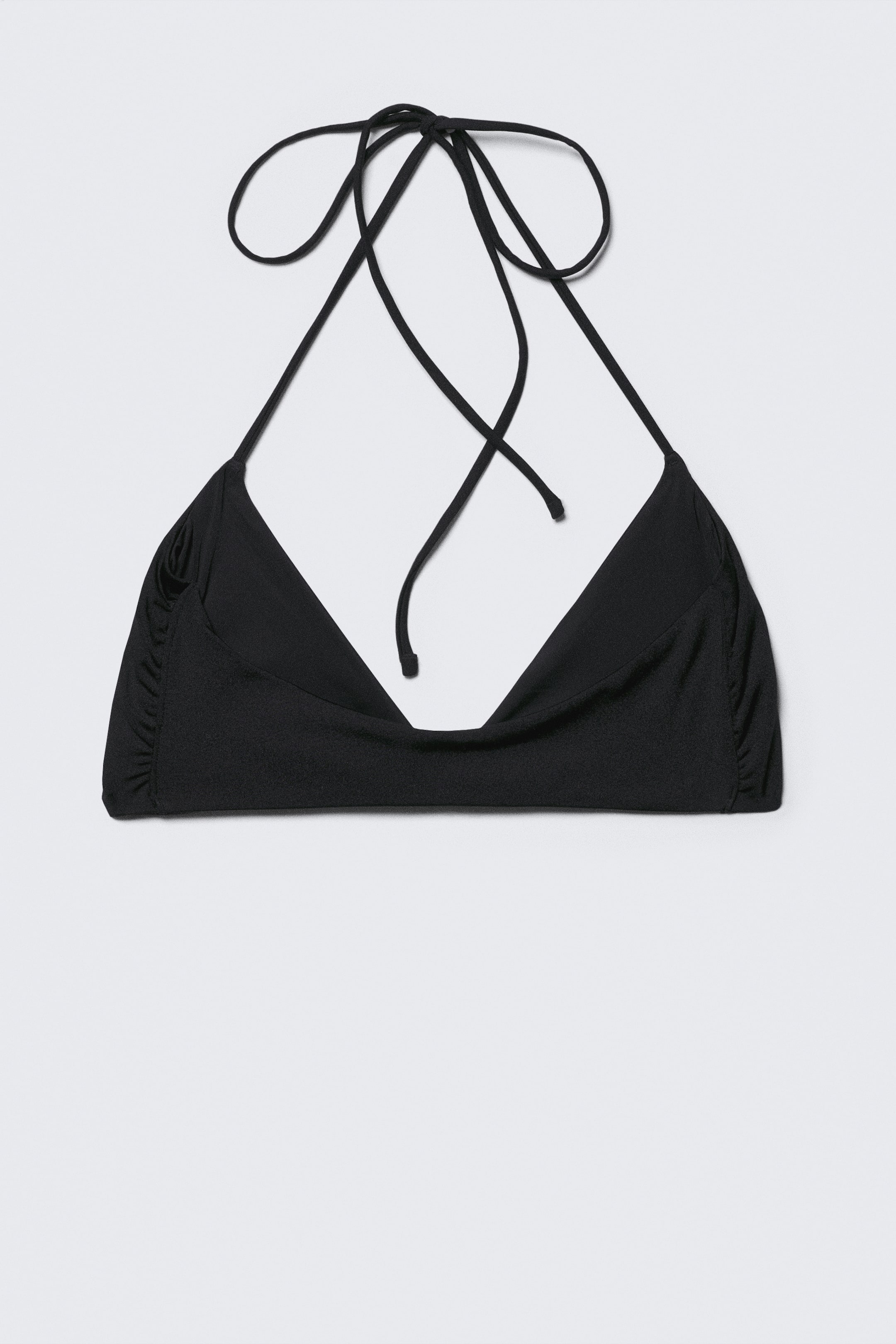 Visualizza immagine più grande: Un top bikini nero stile halter è mostrato FRONTALE, caratterizzato da un design a doppio strato con copertura minima. Presenta lunghe e sottili spalline halter annodate in alto, cuciture laterali leggermente arricciate e un centro frontale drappeggiato.