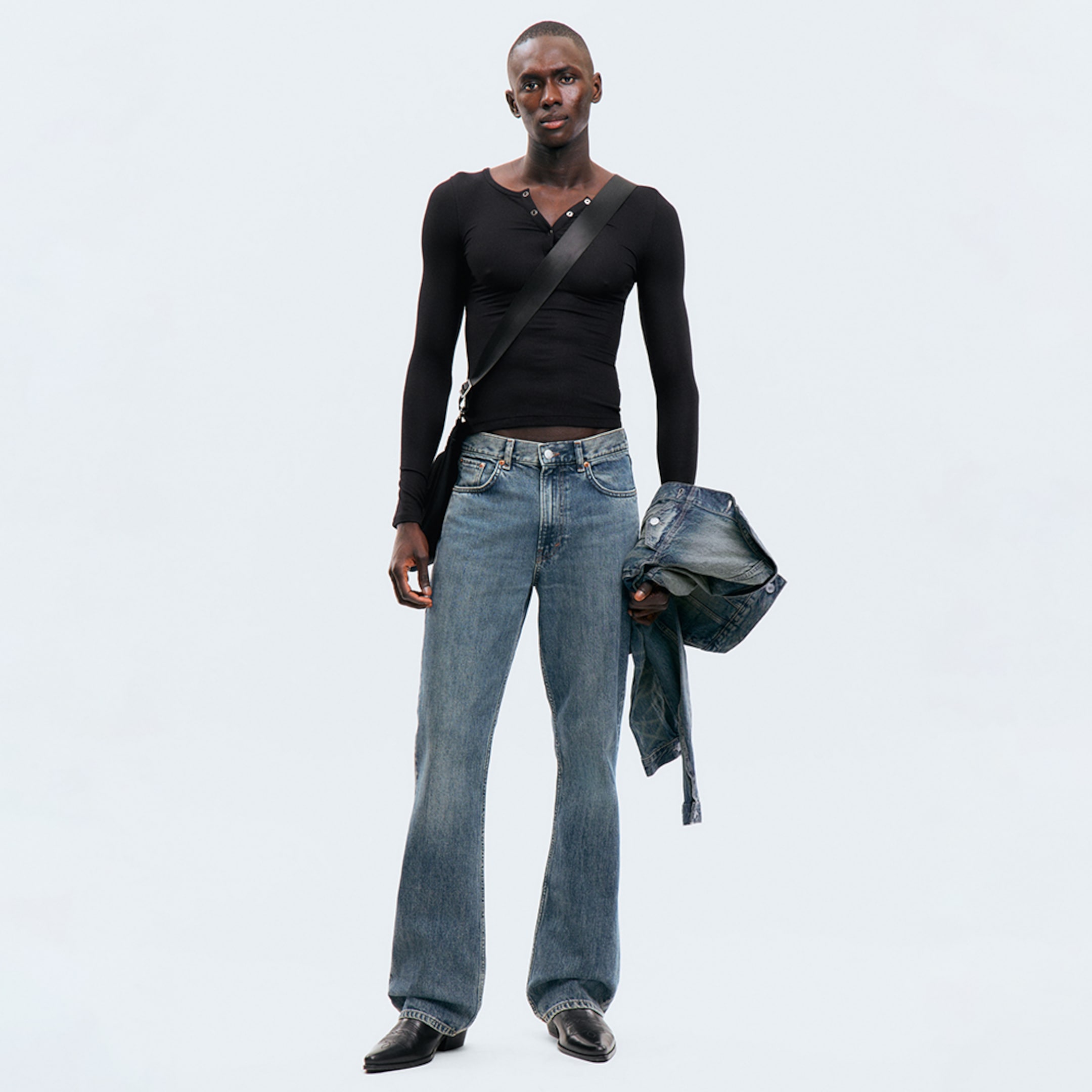 Model wearing a pair of bootcut fit jeans