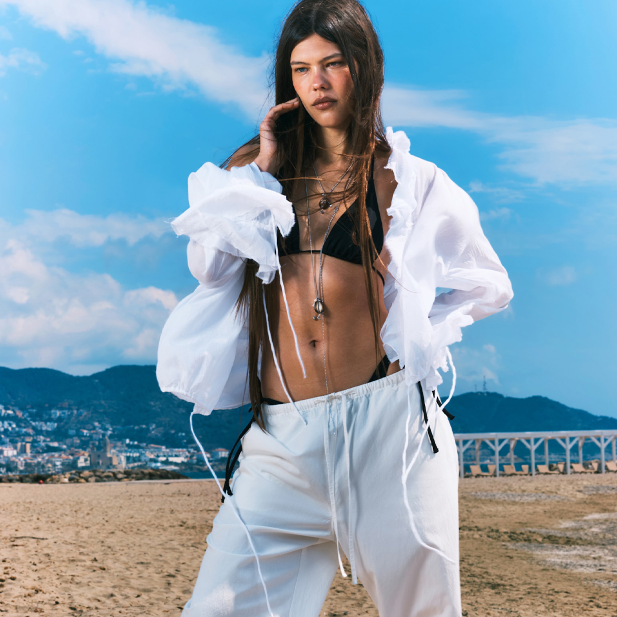 A woman wearing white blouse and trousers