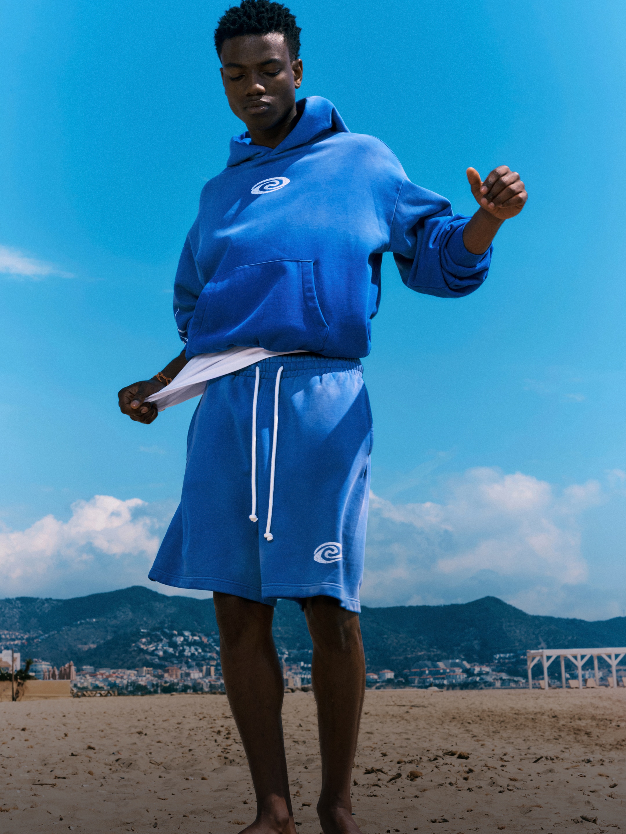 Model wearing a blue fade hoodie with a pair of matching jersey shorts