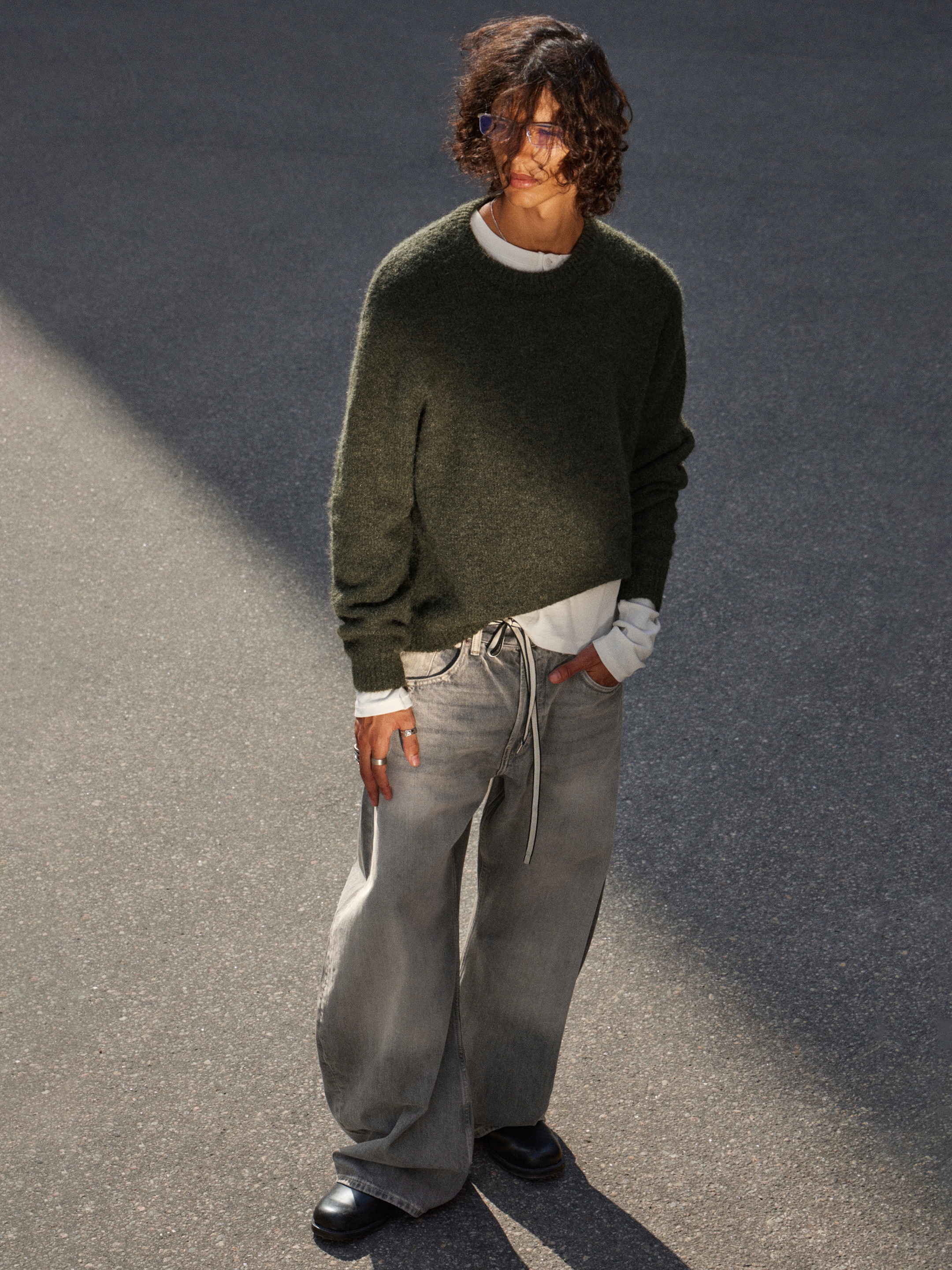Model wearing a green knitted sweater together with a pair of grey Weekday jeans