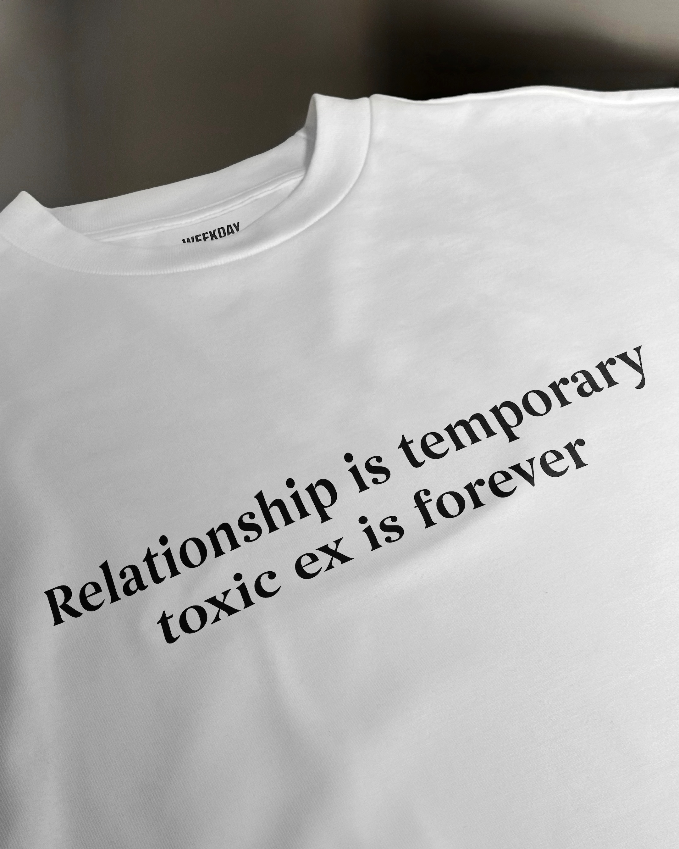 A person wearing a printed white Zeitgeist t-shirt saying “Sorry I missed your call. I was watching it ring till it stopped.”