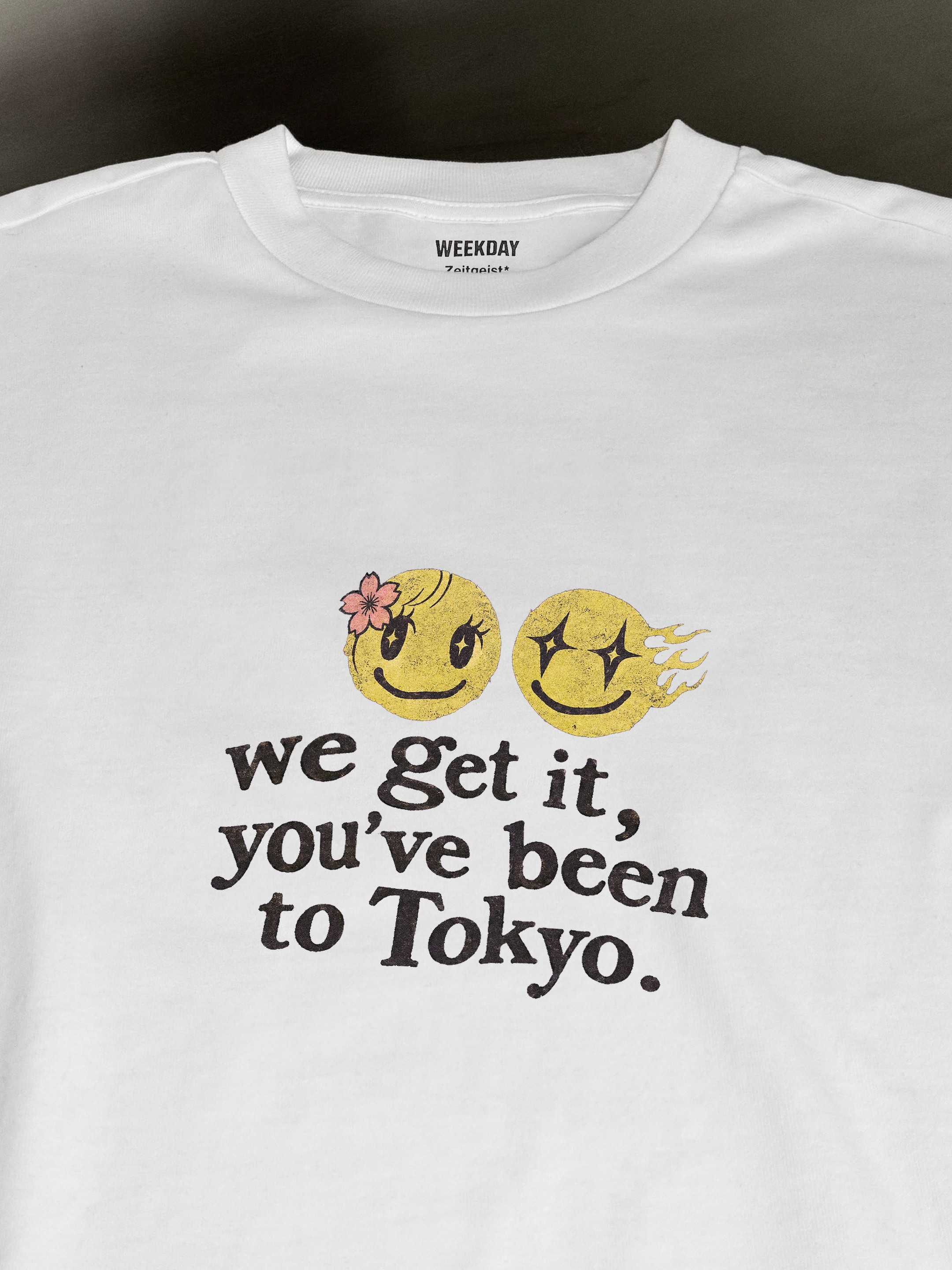 A person wearing a printed white Zeitgeist t-shirt saying “Sorry I missed your call. I was watching it ring till it stopped.”
