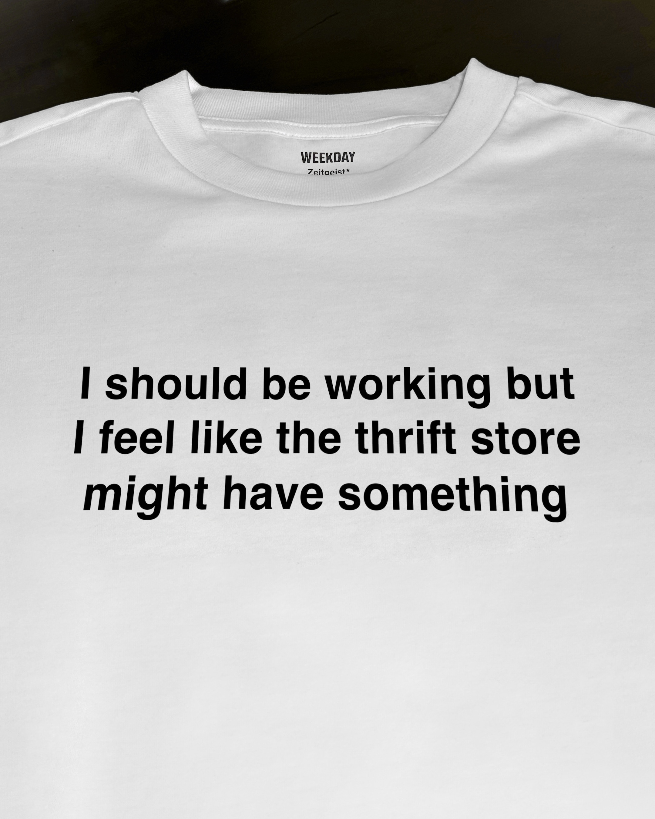 A person wearing a printed white Zeitgeist t-shirt saying “Sorry I missed your call. I was watching it ring till it stopped.”
