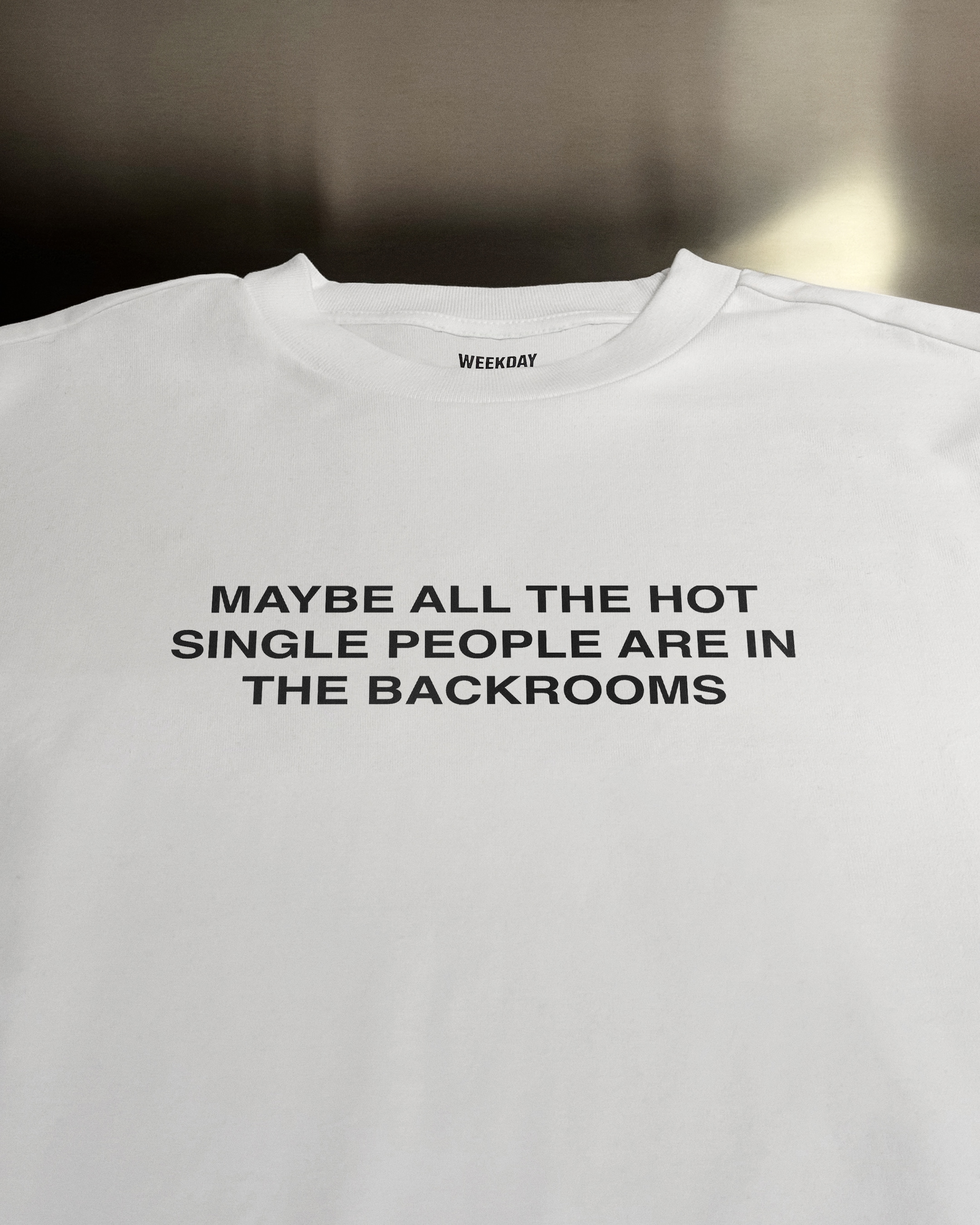 A person wearing a printed white Zeitgeist t-shirt saying “Sorry I missed your call. I was watching it ring till it stopped.”