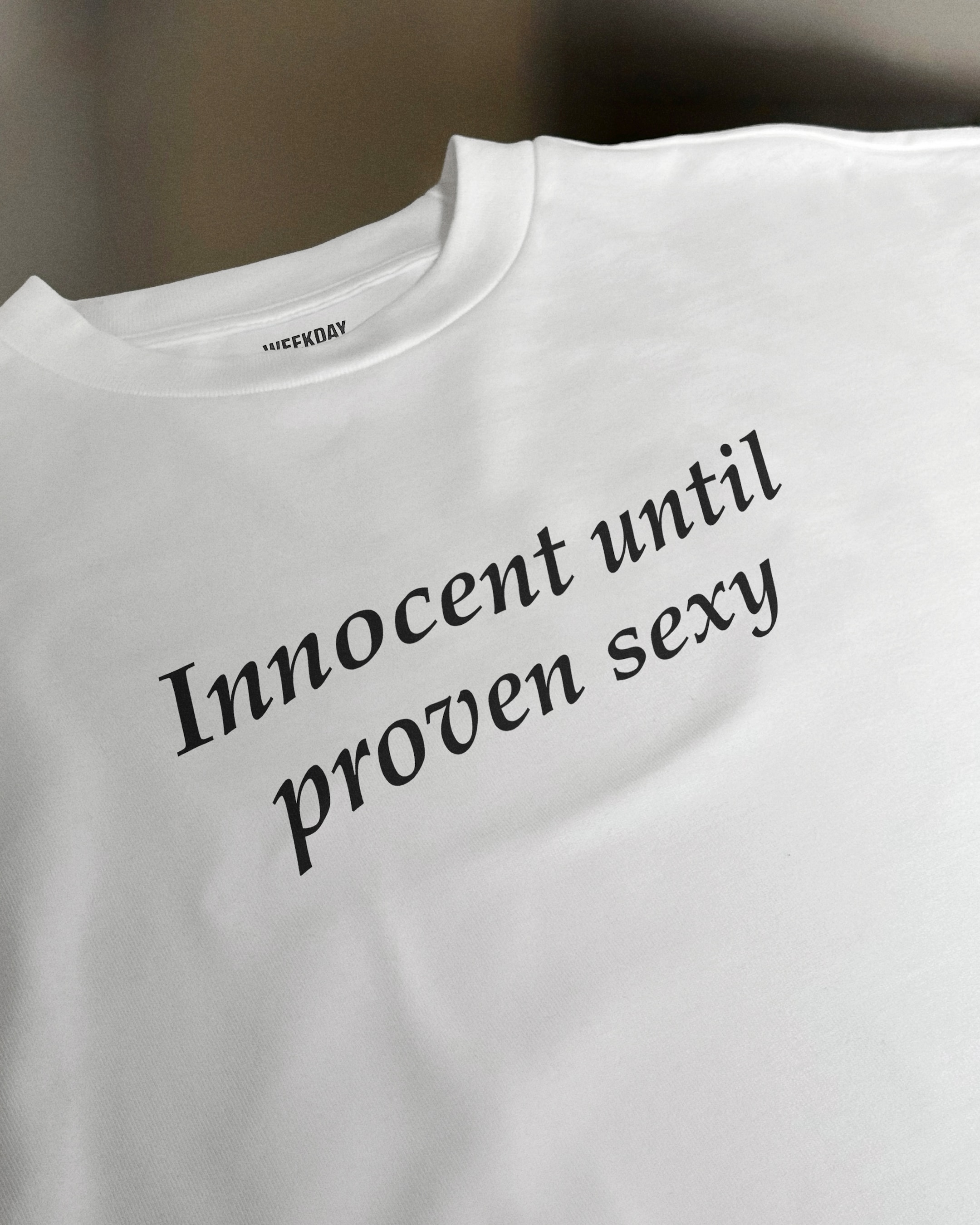 A person wearing a printed white Zeitgeist t-shirt saying “Sorry I missed your call. I was watching it ring till it stopped.”