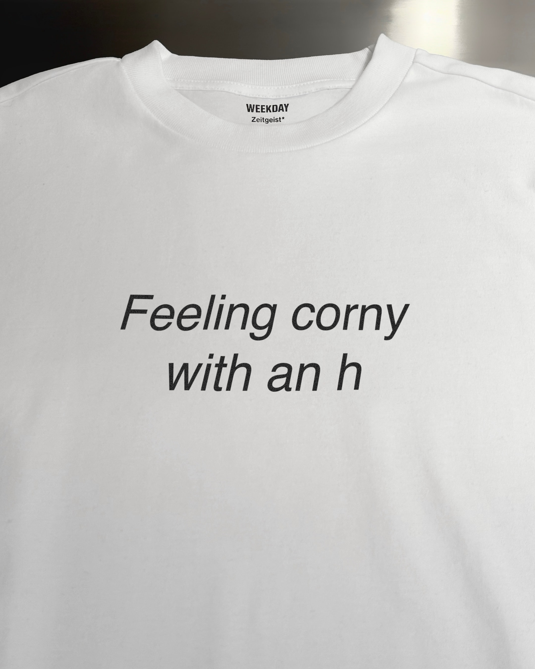 A person wearing a printed white Zeitgeist t-shirt saying “Sorry I missed your call. I was watching it ring till it stopped.”