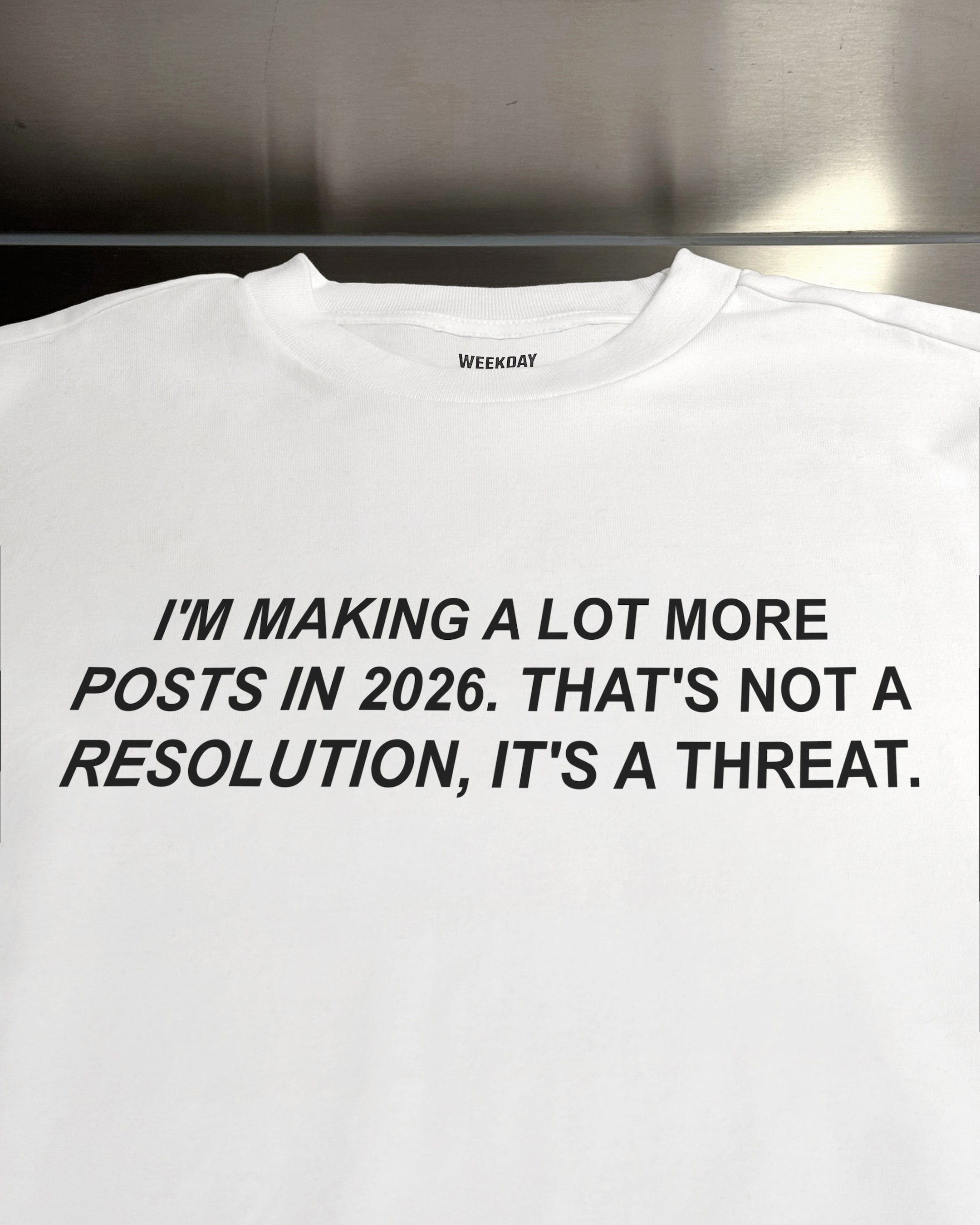 A person wearing a printed white Zeitgeist t-shirt saying “Sorry I missed your call. I was watching it ring till it stopped.”