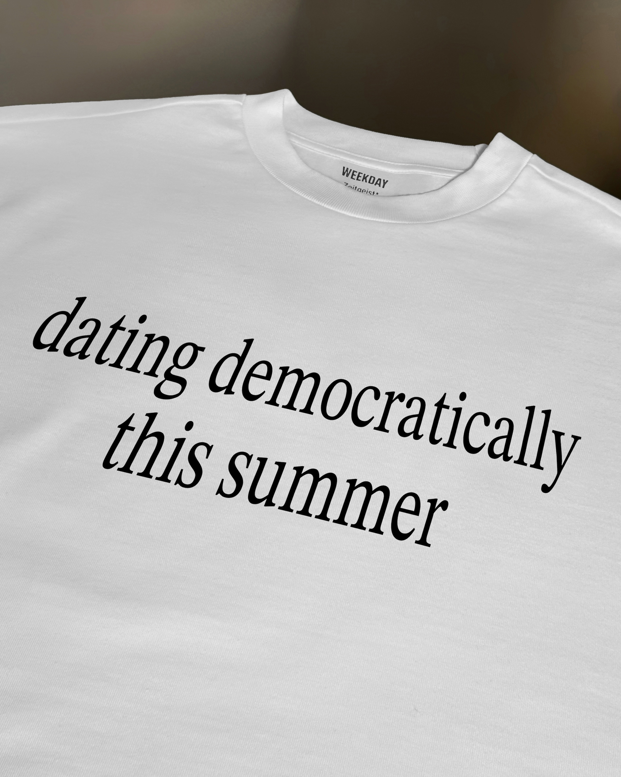 A person wearing a printed white Zeitgeist t-shirt saying “Sorry I missed your call. I was watching it ring till it stopped.”