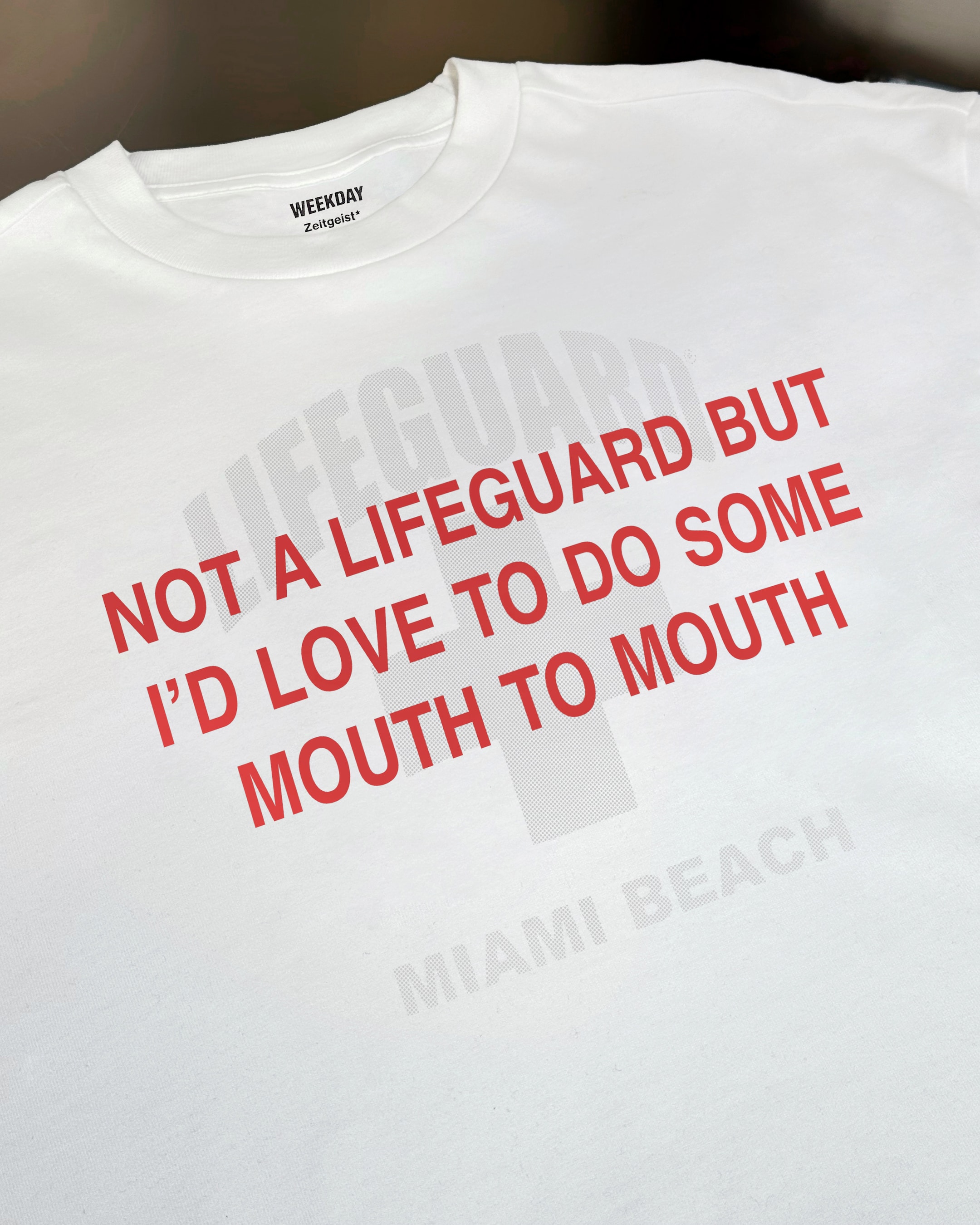 A person wearing a printed white Zeitgeist t-shirt saying “Sorry I missed your call. I was watching it ring till it stopped.”