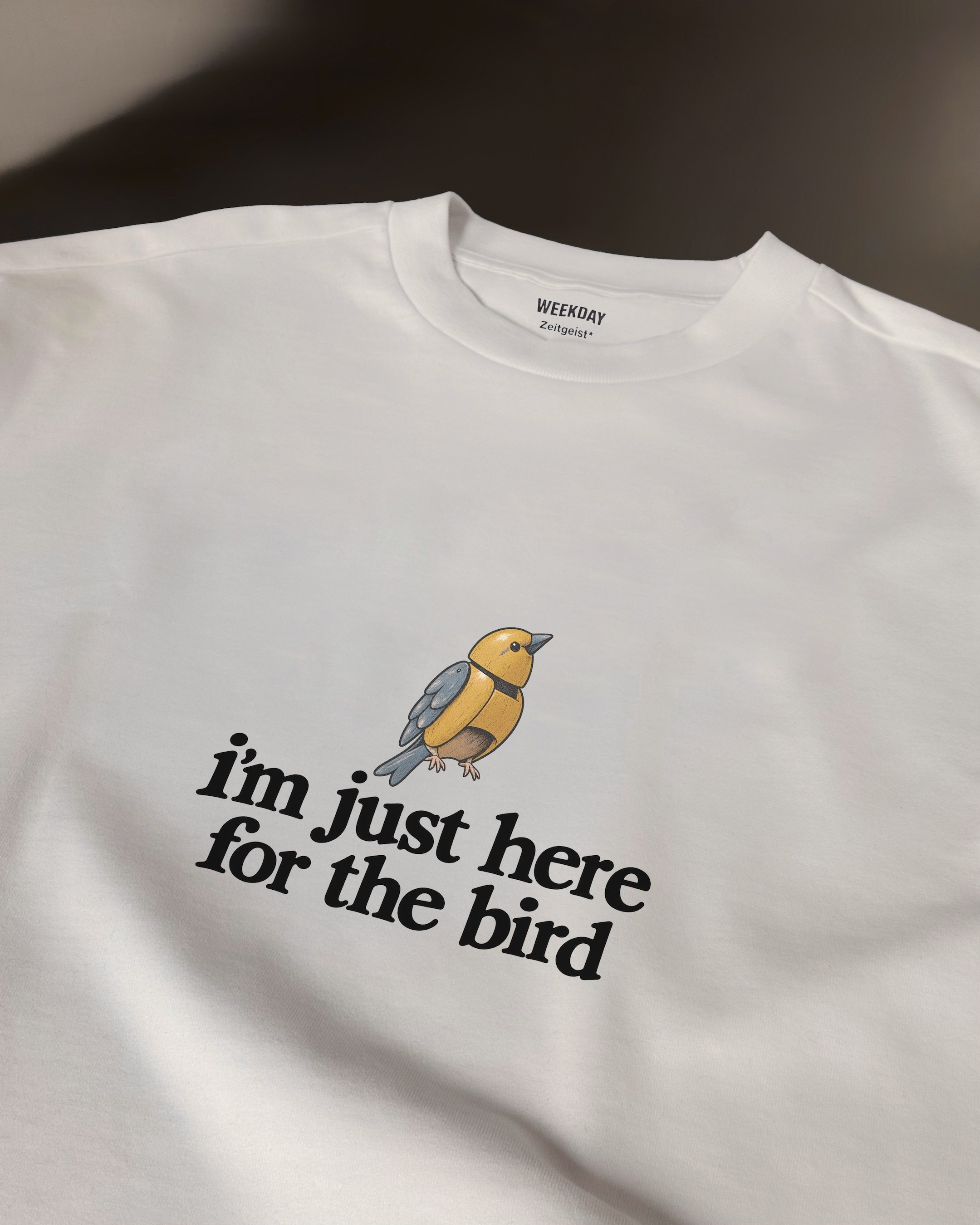 A person wearing a printed white Zeitgeist t-shirt saying “Sorry I missed your call. I was watching it ring till it stopped.”