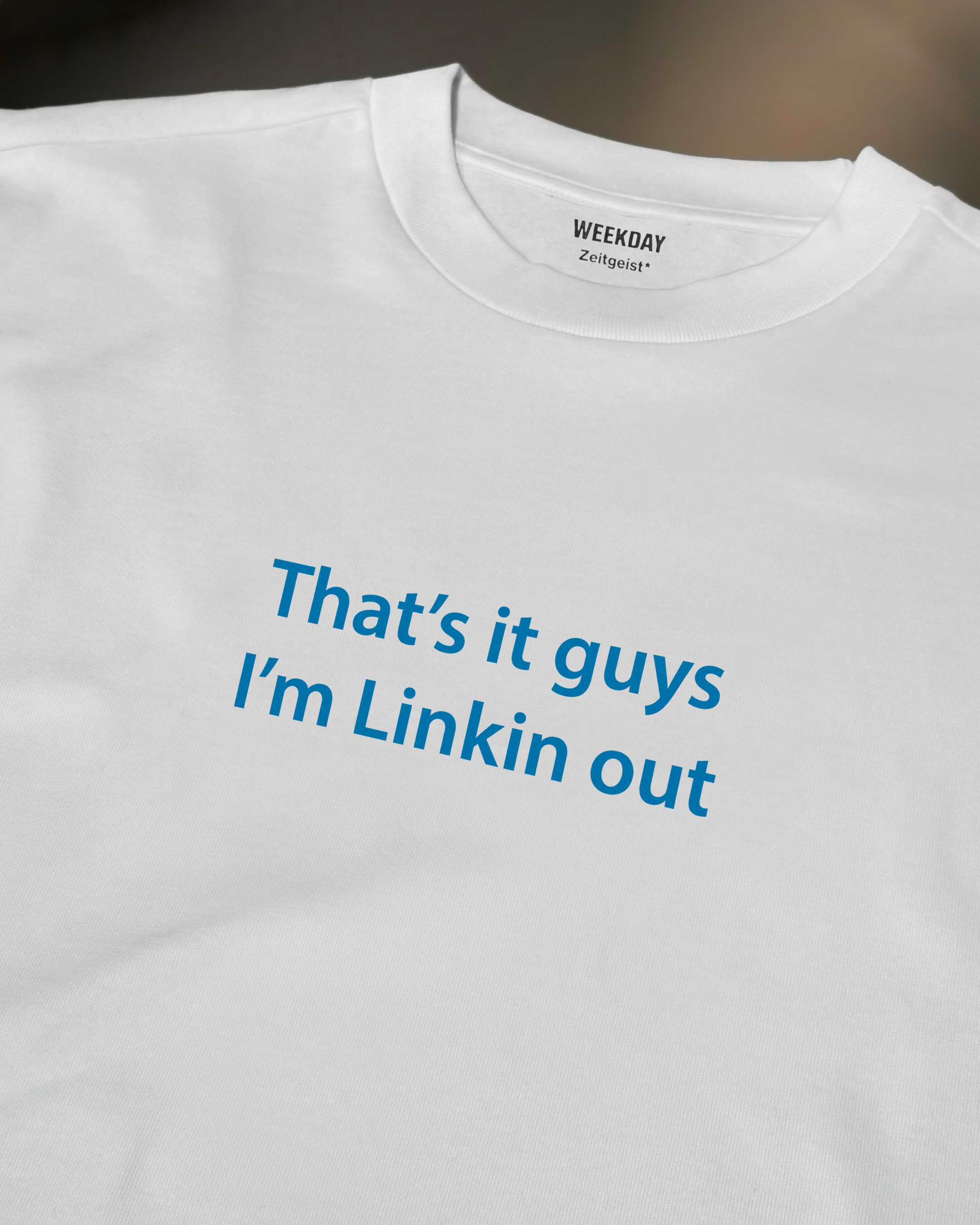 A person wearing a printed white Zeitgeist t-shirt saying “Sorry I missed your call. I was watching it ring till it stopped.”