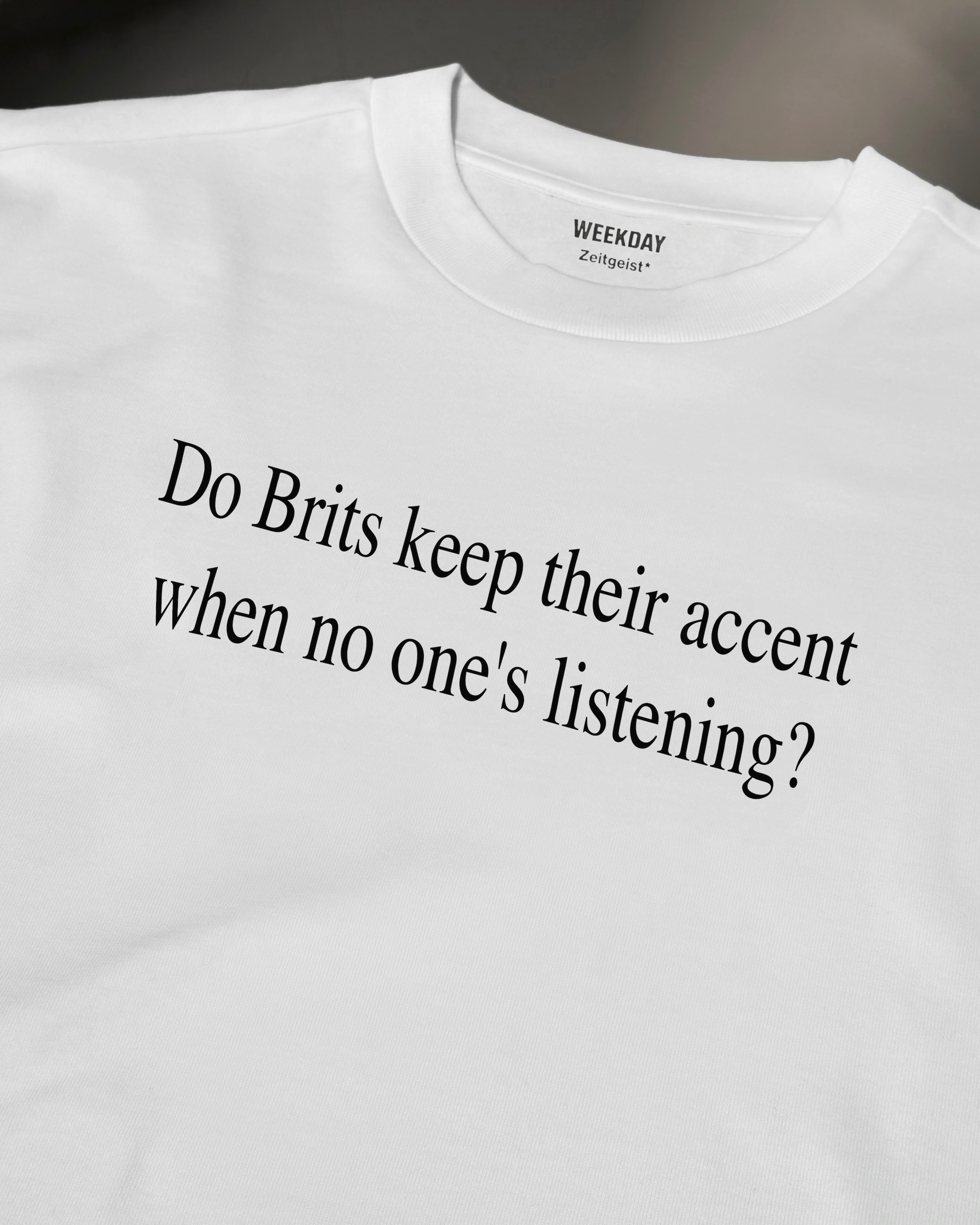 A person wearing a printed white Zeitgeist t-shirt saying “Sorry I missed your call. I was watching it ring till it stopped.”