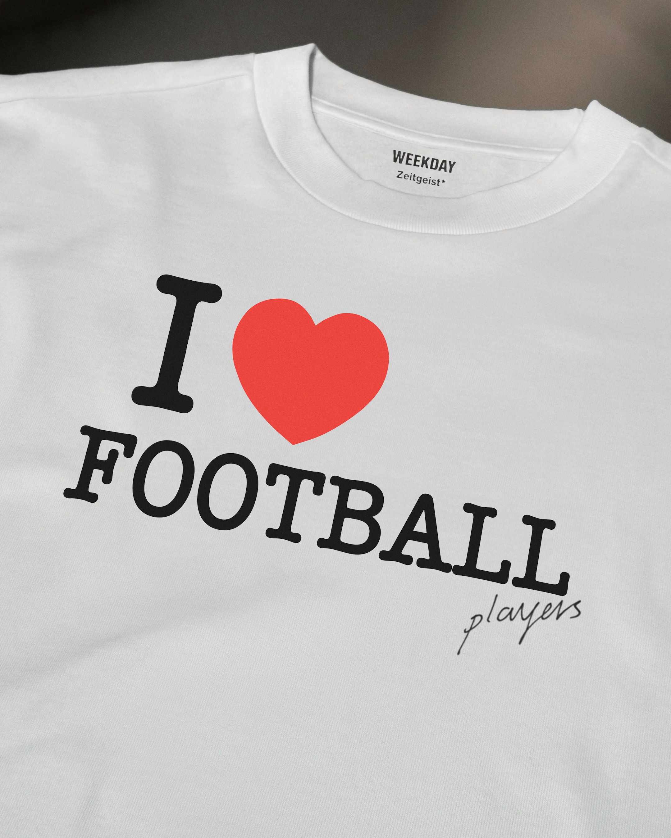 A person wearing a printed white Zeitgeist t-shirt saying “Sorry I missed your call. I was watching it ring till it stopped.”