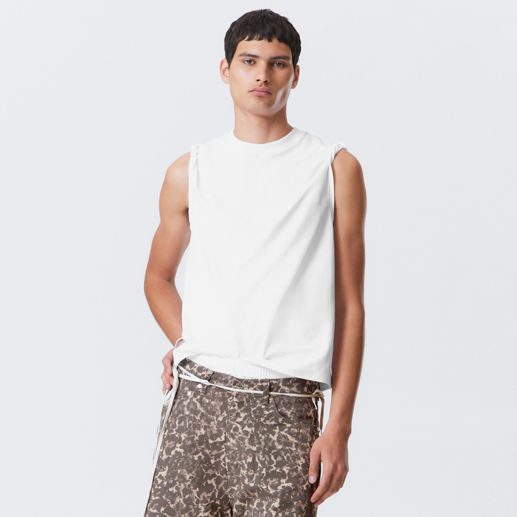 Model wearing a white tank top together with a pair of leopard shorts