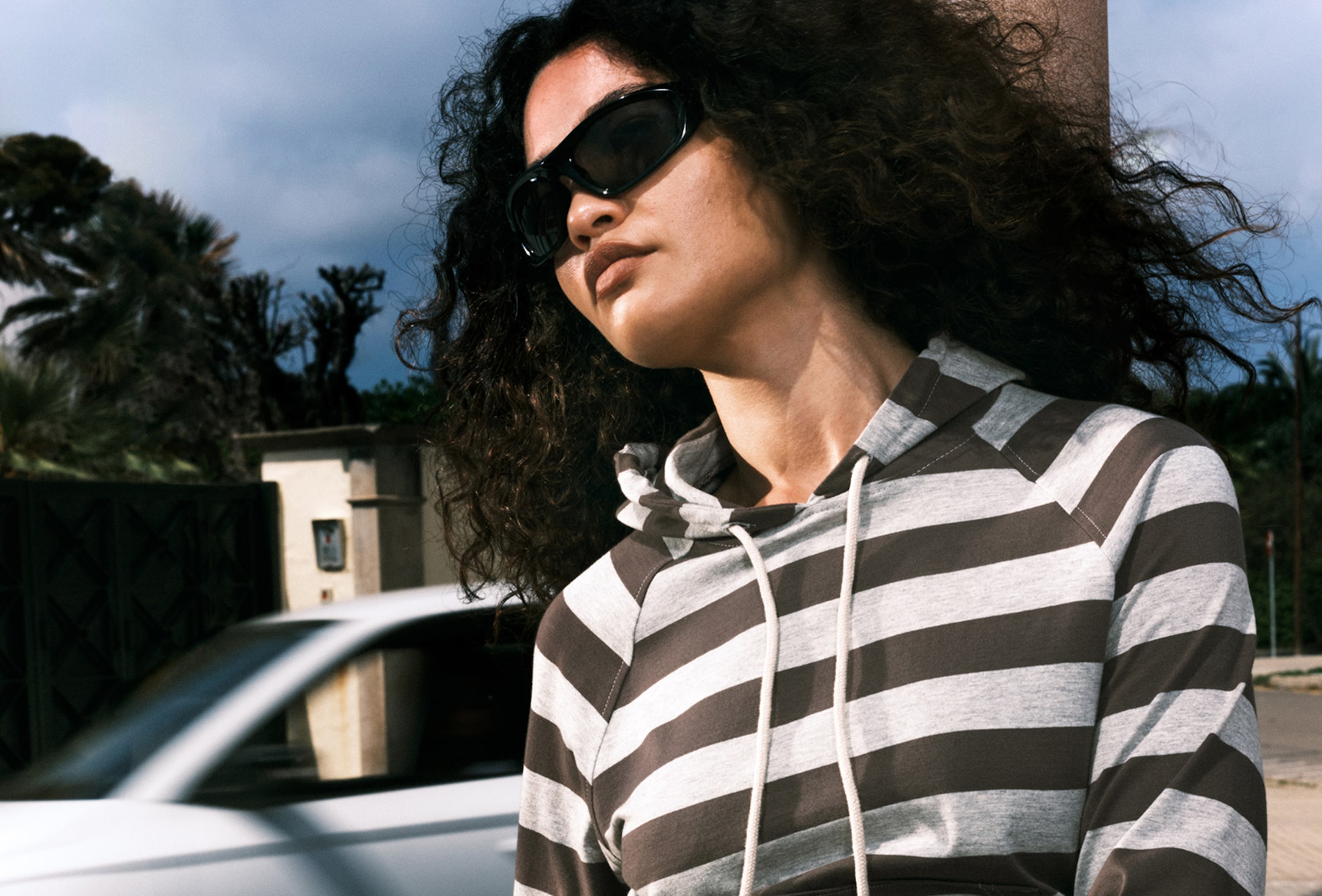 A woman wearing a striped hoodie from Weekday collection