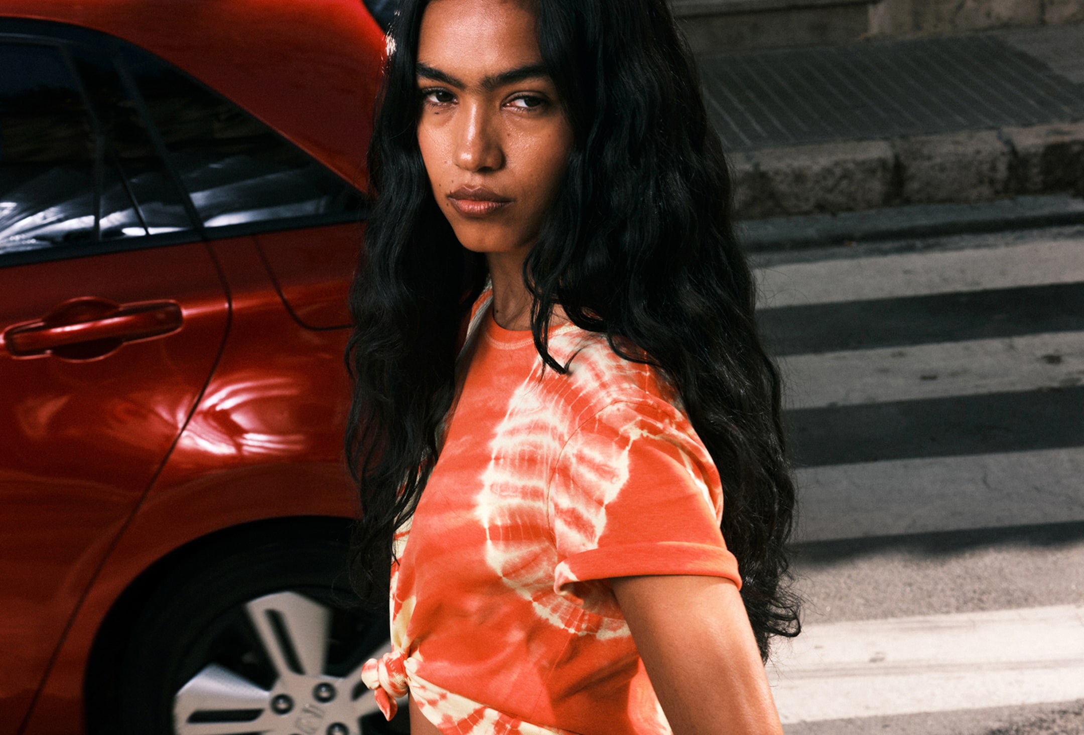 A woman wearing a tie dye top from Monki collection