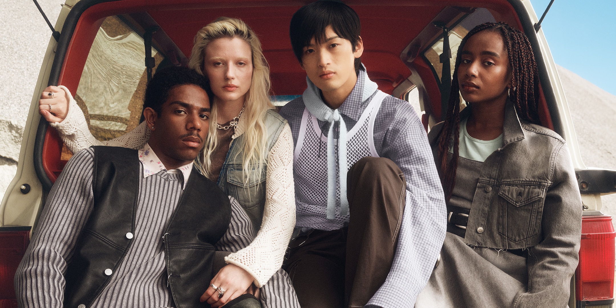 Group of people sitting in the trunk of a car. 