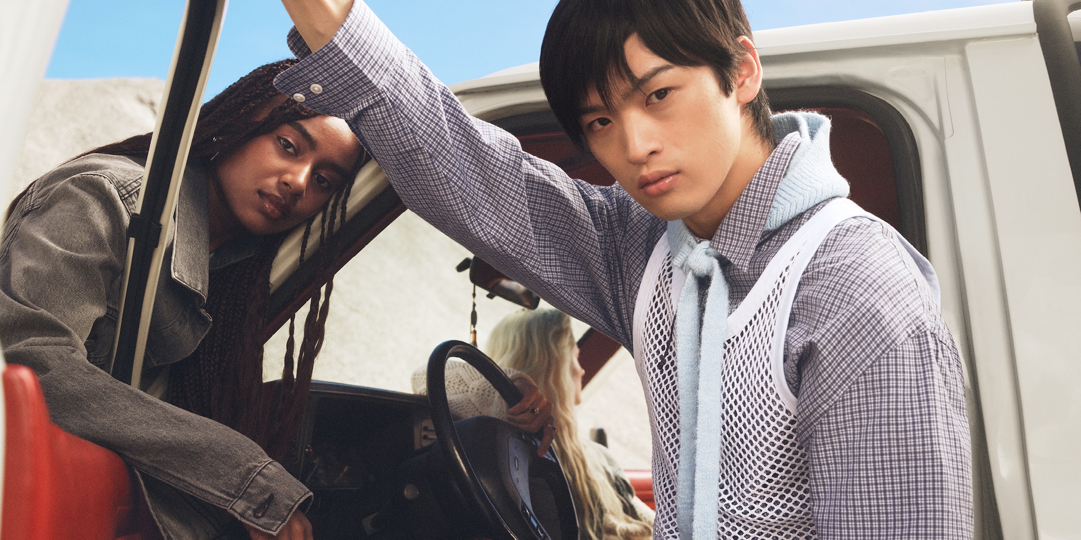 A women and a man hanging outside a car. 